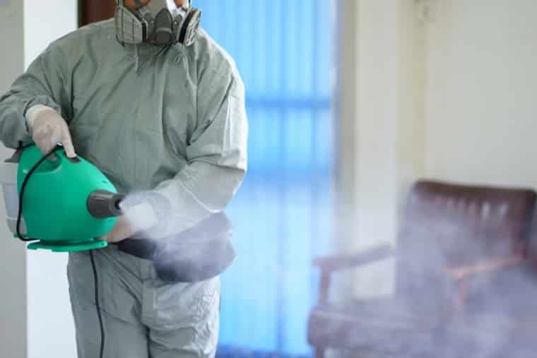 Disinfection Services by man in hazmat suit